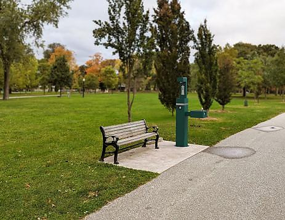 Borne d'eau extérieure Oasis verte installée dans un parc, près d'un banc